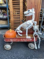 Side view of wagon with skeleton dog, human skeleton and pumpkin inside
