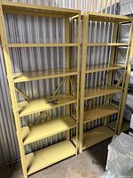 Two yellow metal shelving units with six shelves each shown side by side
