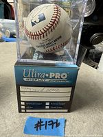 Signed baseball in acrylic cube on Ultra PRO sleeve