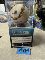 Front view of autographed baseball in Ultra PRO display cube with sleeve