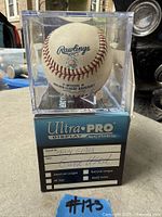 Baseball in cube showing Rawlings logo, MLB text, hologram and sleeve markings