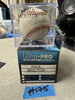 Signed baseball inside acrylic cube on top of Ultra PRO box, showing signature and packaging