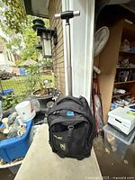 Front side view of black rolling backpack with handle extended