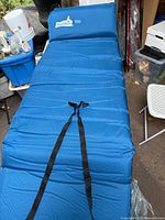 Full view of blue single air mattress with pillow and straps