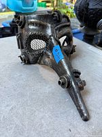 Front three-quarter view showing beak, mesh eyes, gears, tubing