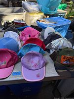 Overview of assorted baseball caps laid out on table