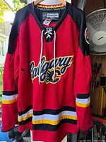 Full front view of Calgary Flames jersey on hanger