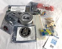 Group shot of all components: Photon tins, relay shield, breadboard, LEDs, headers, resistors