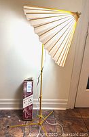 Assembled yellow tripod lamp beside boxed identical lamp