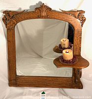 Full view of oak mirror showing carved frame and candle shelf