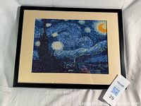 Frontal view of framed beaded artwork with mat and frame