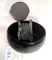 Black ceramic bowl with folded extendable shaving mirror inside
