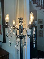 Close view of illuminated candelabra head showing crystal strands and bulbs