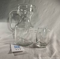 Large and small clear glass pitchers side by side