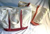 Front view of both Lands’ End canvas totes; burgundy-trim bag left, rust-trim bag right