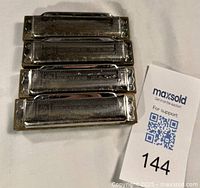 Four harmonicas stacked front view