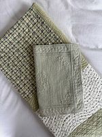 Quilt and pillowcase folded showing plaid, floral, and solid sage panels