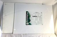 Front view of both canvas boards: one sealed with label, one unwrapped