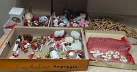 Overview of assorted ornaments and wooden bead strands in boxes