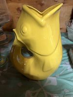 Front view of yellow fish-shaped stoneware pitcher