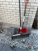 Overall lot showing two snow shovels and two sprinklers on ground