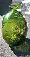 Front view of olive green Blenko art glass vase showing overall shape and color