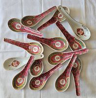 Group of 14 porcelain Chinese soup spoons on cloth background