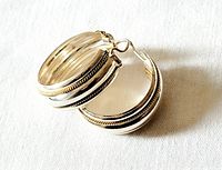 pair of sterling silver and 10K gold hoop earrings overlapping to display design detail