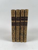 Spine view of all four volumes showing gilt tooling and volume labels