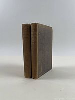 Two brown cloth volumes standing spine out