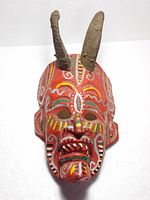 Front view of painted wooden mask with horns