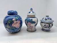 Three ginger jars with lids displayed upright