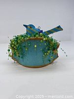 Front view of painted bluebird on beaded nest sculpture