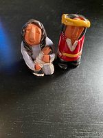 Front view of both signed red clay figurines