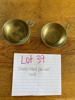 Top view of two brass porringer bowls showing etched interiors and handles