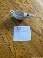 Top view of ceramic invalid cup showing red cross emblem, spout and handle