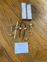 All eight watches laid out with two watch boxes