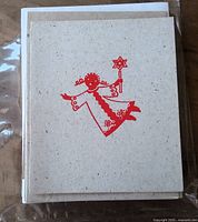 Front of greeting card showing red angel design