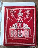 Front view of stacked red cards showing Gloria design and white envelopes behind