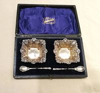 boxed set showing two salts and two spoons in fitted interior