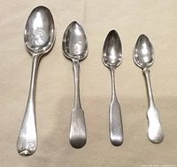 Front view of four silver spoons