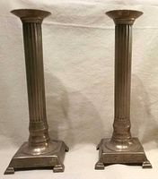 Front view of both brass candlesticks showing fluted columns and square bases