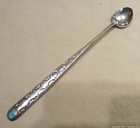 Full view of sterling cocktail spoon showing stamped handle and turquoise inset