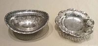 Both silver-plated bonbon dishes, oval and round, top view