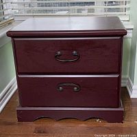 Front view of nightstand showing drawers and handles