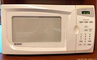 Front view of white Kenmore Quick Touch microwave with digital display