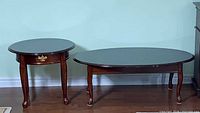 Round end table and oval coffee table side by side showing overall design and finish