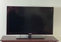 Front view of Samsung TV powered off on stand