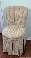 Front view of paisley upholstered slipper chair with pleated skirt