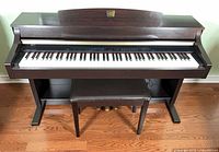 Front view of Yamaha Clavinova digital piano with bench underneath